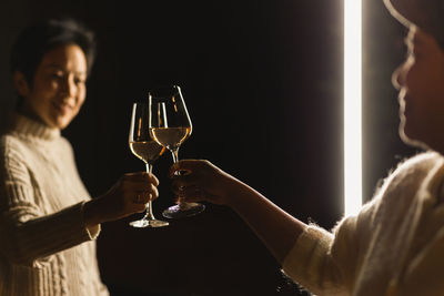 Midsection of woman holding wineglass