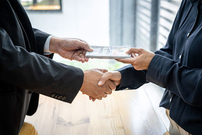 Midsection of business people shaking hands