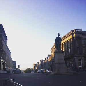Statue in city against clear sky