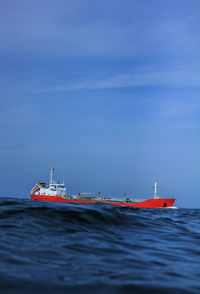 Boat sailing on sea against blue sky