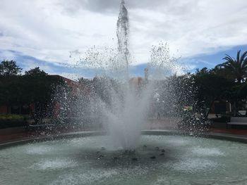 Water splashing in fountain against sky