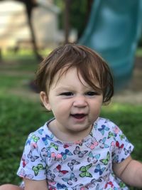 Close-up portrait of cute baby girl sitting at playground