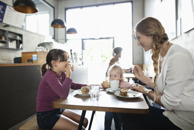 Mother and daughters eating desserts in cafe