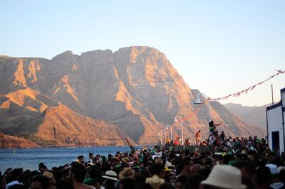 People on mountain against clear sky