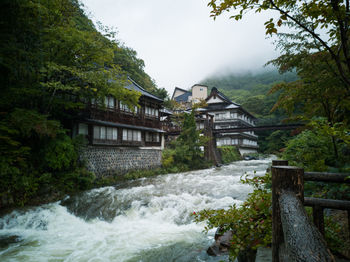 River flowing by building against sky