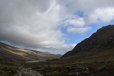 Scenic view of mountains against cloudy sky