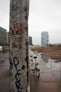 Close-up of graffiti on wall by city against sky