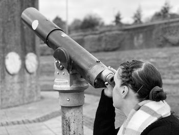 Portrait of a woman looking through a telescope 