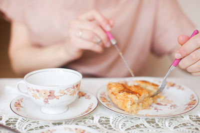 Midsection of woman having breakfast on table
