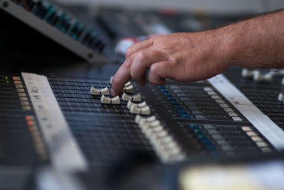 Technician adjusting sound mixer at studio