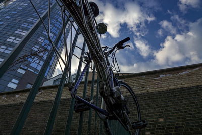 Low angle view of bicycle by building against sky