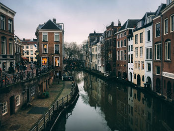 Canal amidst buildings against sky