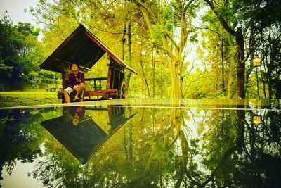 Man standing by lake against trees