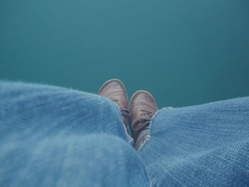 Low section of woman legs against calm lake