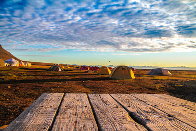 Tent on landscape against cloudy sky