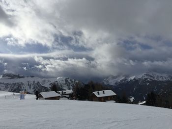 Houses on snowcapped mountain against sky