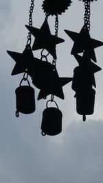 Low angle view of silhouette hanging against sky