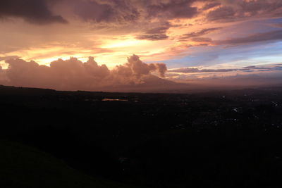 Scenic view of silhouette landscape against dramatic sky during sunset