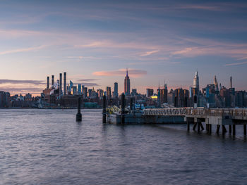 Sunset over east river midtown manhattan skyline and north 5th street pier at brooklyn