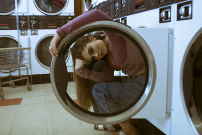 Portrait of woman looking through laundromat door