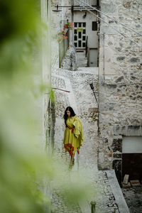 Portrait of woman standing by building