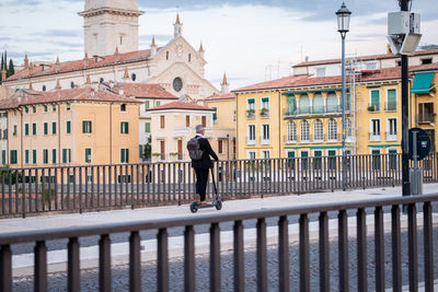 Rear view of woman walking on building in city