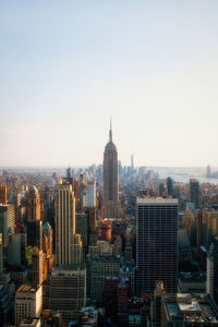 Aerial view of buildings in city against clear sky