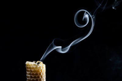 Close-up of candle against black background