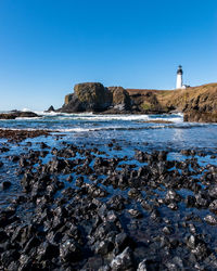 Scenic view of beach against clear blue sky