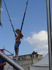 Low angle view of boy playing on playground