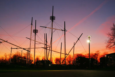 Low angle view of silhouette fountain and street light against sky at dusk