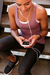 Midsection of young woman using mobile phone