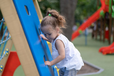 Side view of girl on play equipment at park