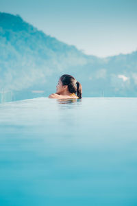 Woman swimming in sea against clear sky