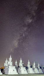 Low angle view of built structure against star field at night