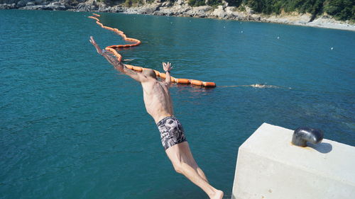 High angle view of shirtless man in sea