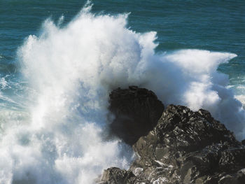 High angle view of waves crashing on rocks at shore