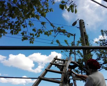 Low angle view of woman working against sky