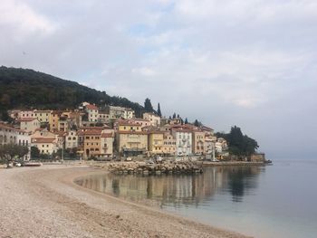 Town by sea against sky