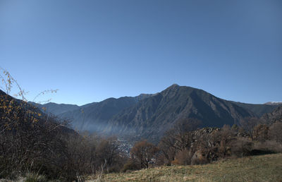 Scenic view of mountains against clear blue sky