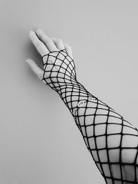 Close-up of hand holding umbrella against white background