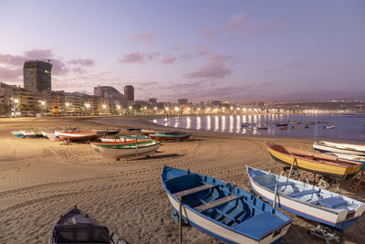 Boats moored at beach against sky