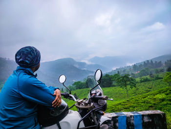 Young man motorcycle rider enjoy the beautiful mountain view at morning from flat angle