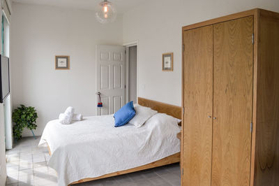 Bed base, bedroom with mat on the floor, clay pot in the background, 