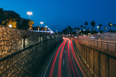 Light trails on road against sky at night