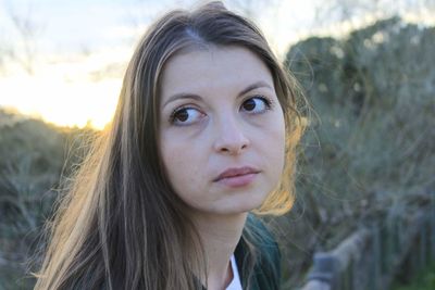 Close-up portrait of beautiful woman against sky