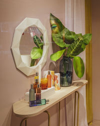 Shelf in the bedroom with a mirror, bottles of perfume and balm