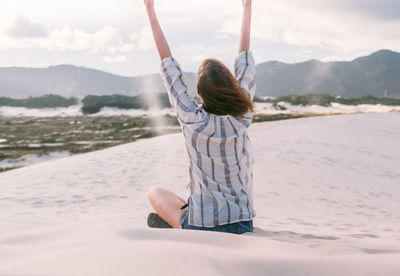 Rear view of woman on sand against sky