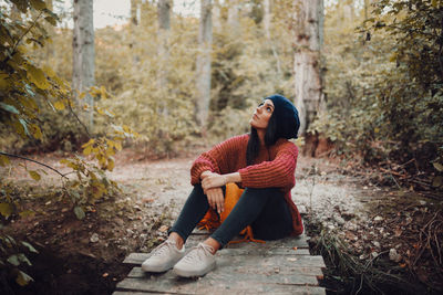 Portrait of young woman sitting on rock