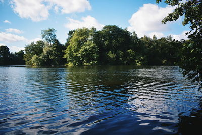 Scenic view of lake by trees against sky